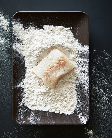 يقلى فيليه سمك الفحم في مزيج الدقيق